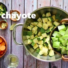 Fresh food ingredients being placed into a cooking pot.