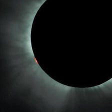 A total solar eclipse darkening the daytime sky