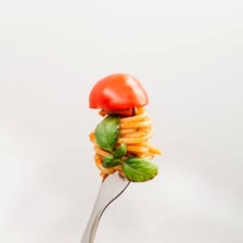 A fork lifting spaghetti wound into a neat coil