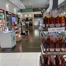 An airport duty-free shop displaying perfume and alcoholic drinks.