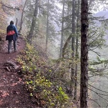 A hiker laboring up a steep muddy path