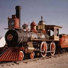 A vintage steam locomotive viewed from the front.
