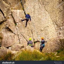 A climber descending a rock face by rope.
