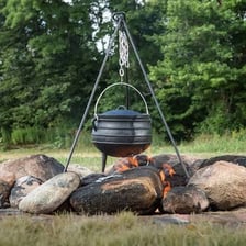 A large iron cauldron suspended over a fire