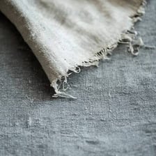 Fabric unraveling into loose threads at its edge