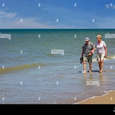 A person walking through shallow water while paddling.