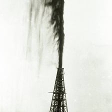 An oil well gushing crude oil into the air.