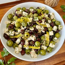 A block of feta cheese served with olives.