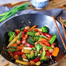 Vegetables being stir-fried in a hot wok
