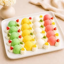 Scoops of brightly coloured fruit sorbet in a dessert dish.