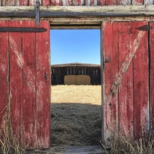 A large barn door shown open on a farm building