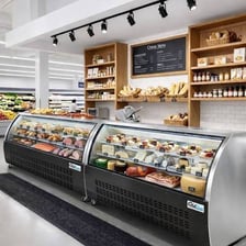 A delicatessen counter displaying prepared foods, cheeses, and meats.