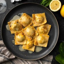 Several pieces of filled ravioli served on a plate.