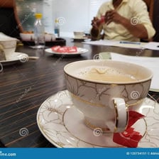 A cup of tea beside a plate during a work break