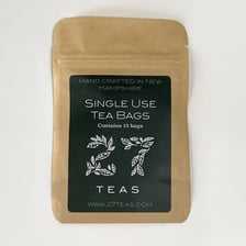 A tea bag shown with tea leaves inside it.