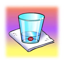 A solid dissolving into a clear glass of water.