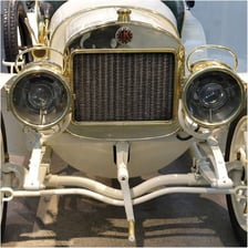 A hand crank being used to start a vintage motor