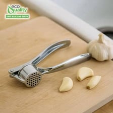 A handheld garlic press squeezing a garlic clove
