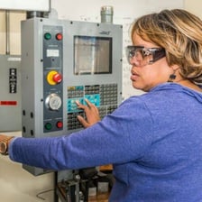 A worker carefully repairing a machine.
