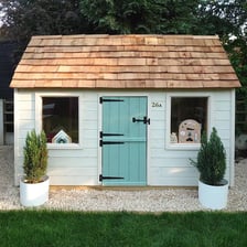 A small children's playhouse in a garden