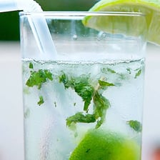 A mojito cocktail garnished with mint and lime.