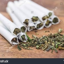 A rolled marijuana cigarette on a table.
