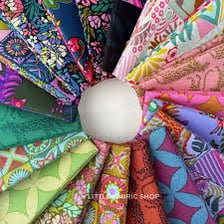 Rolls and folded pieces of colorful textile fabric.