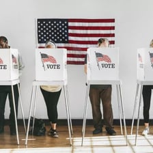 A person casting a ballot at a polling station.