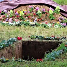 A burial scene showing a grave and mourners.