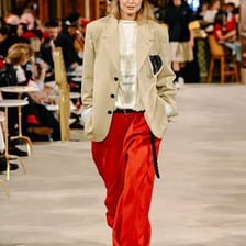 A fashion model walking along a runway during a fashion show