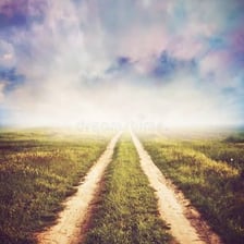 A road extending toward an open horizon, suggesting no fixed endpoint.
