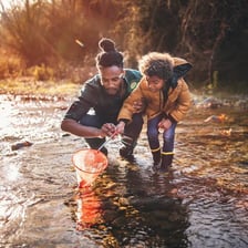 An adult father figure giving guidance to a child.