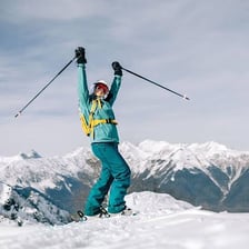 A skier descending a snow-covered mountain slope