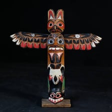Carved Indigenous totem poles displayed outdoors