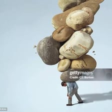 A person carrying several heavy burdens.