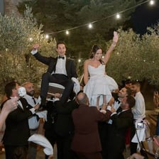 Dancers holding hands in a circle during a hora.