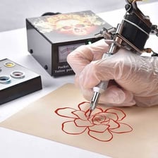 Tattoo ink beside a tattoo machine.