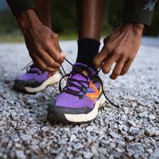 A person threading shoelaces through a sneaker.