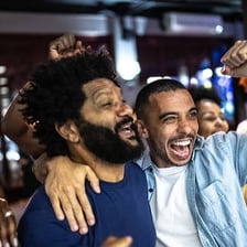 Enthusiastic fans cheering together at a sporting event.