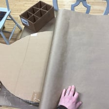 A person applying paste to attach a sheet of paper.