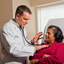 A doctor caring for a patient during medical treatment.