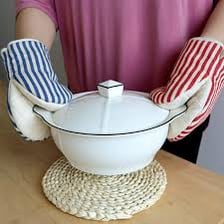 A cloth potholder being used to handle a hot pot
