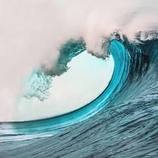 A breaking ocean wave with a foamy whitecap.