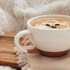 A latte topped with a layer of milk foam in a cafe cup