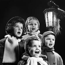 A group of singers performing a Christmas carol.
