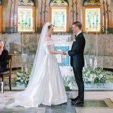 A bride and groom exchanging vows at a wedding altar.