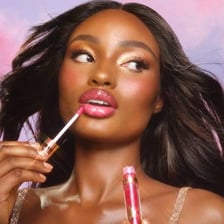 A close-up view of lip gloss being applied to a person’s lips.