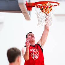 A basketball player dunking the ball through a hoop.