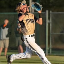A baseball rising high in the air as a pop fly.