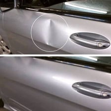 A visible dent in the door of a car.